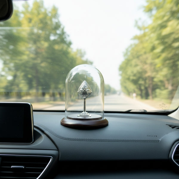 Silver Vel under a dome displayed on a car dashboard 
