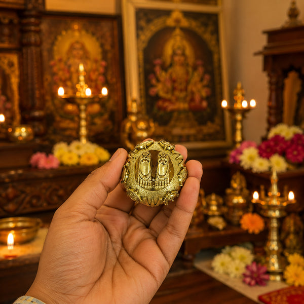 Brass Perumal Patham held in hand for size reference near pooja altar