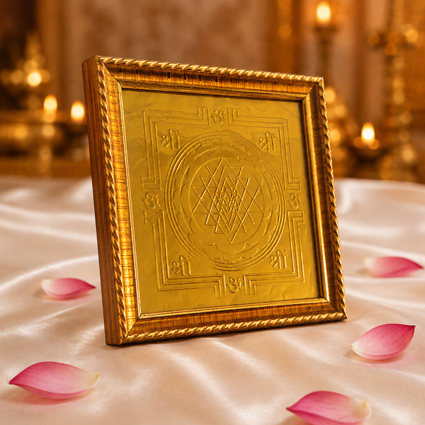 Angled view of Sri Chakra Yantra frame on white satin with pink petals