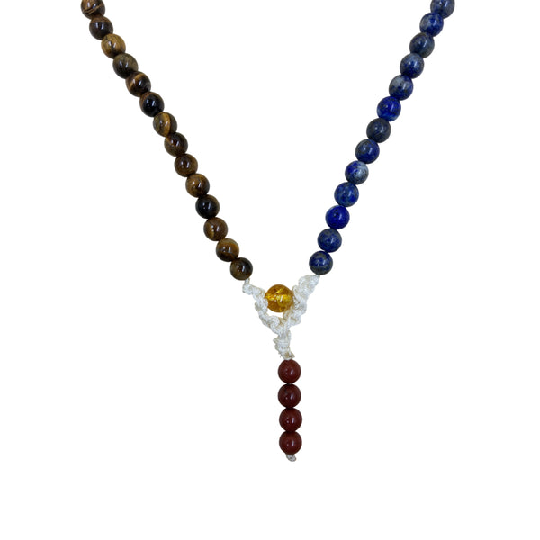 Close-up detail of a 7 Chakra mala necklace showing the white hand-knotted cord, yellow guru bead, and red jasper stones.