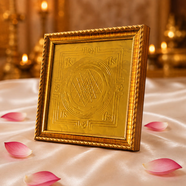 Gold Sri Chakra Yantra frame on white satin with rose petals and candles