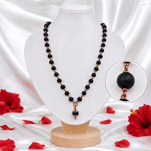 Close-up of black Mangalsutra beads connected with copper-toned wire detailing