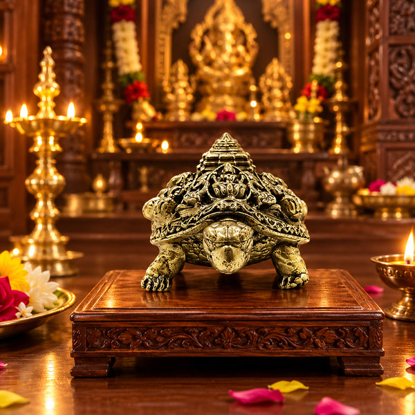 Sacred brass Ashtalakshmi Kurma statue placed on a traditional home pooja altar illuminated by oil lamps.