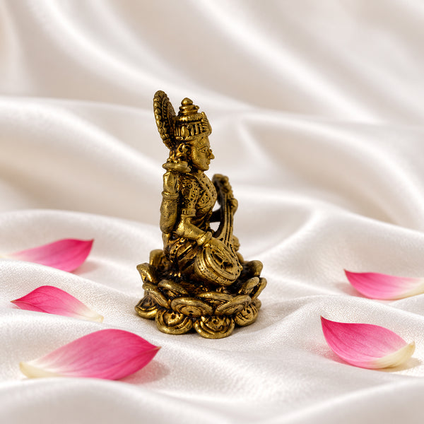 Side view of the brass Saraswati idol showing the veena and lotus base