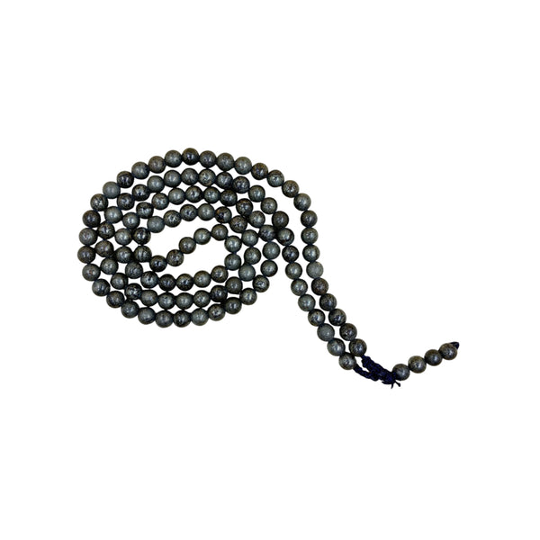 A traditional Pyrite crystal prayer mala coiled in a spiral on a plain white background, highlighting the metallic grey and gold tones of the polished stone beads.