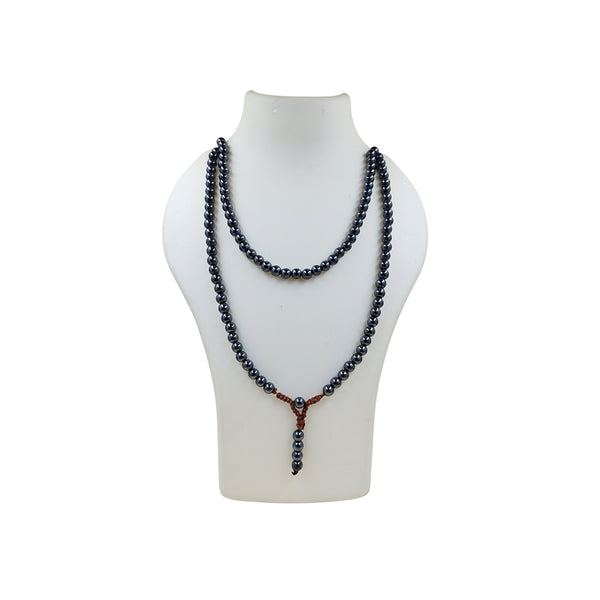A Hematite crystal prayer mala doubled around a white mannequin bust, highlighting the reflective surface of the metallic beads