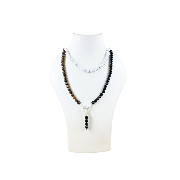 A long combination mala made of Tiger's Eye, Black Tourmaline, and Howlite crystal beads, worn doubled over a white display bust to show the length and variety of stones.