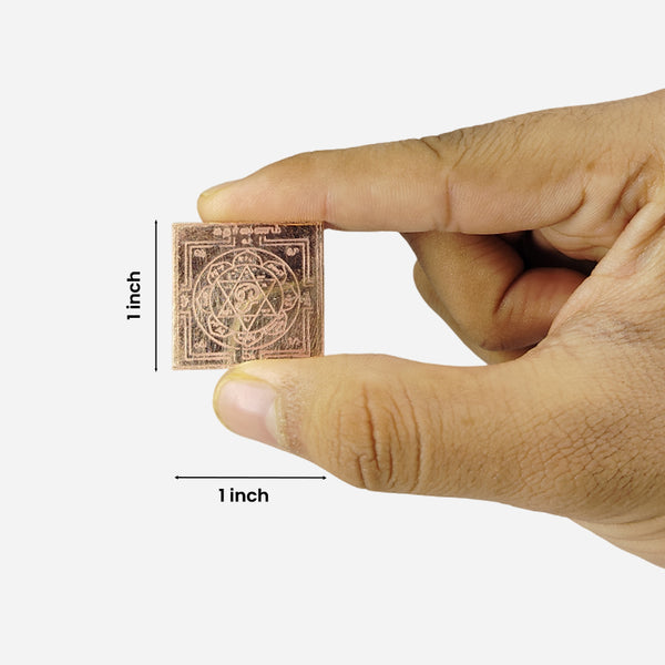 Pocket sized yantram held between fingers with a measurement label indicating its size.
