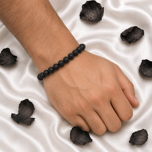 A person wearing the black volcanic lava stone bracelet, showcasing its matte texture and comfortable elastic fit