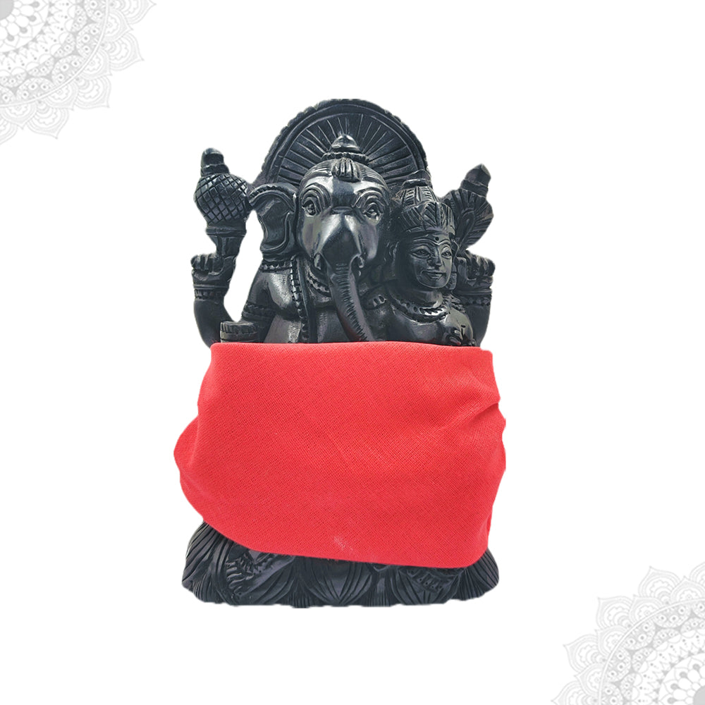 A black statue of Ganesha, the Hindu god of wisdom, wearing a red vesti, set against a white background.