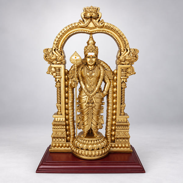 Gold Murugan statue with ornate temple arch, jewellery and vel on a wooden base