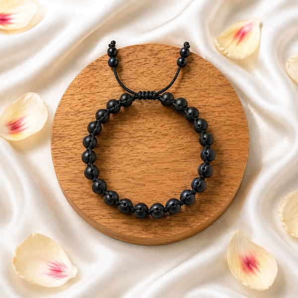 Overhead view of the original karungali kattai triple row bracelet showing the natural dark ebony wood texture.