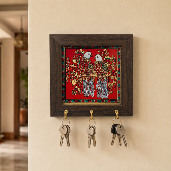 Tanjore art key hanger with dove pair painting hung on wall with keys