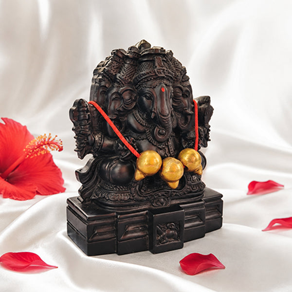 Three-faced Ganesha idol decorated with hibiscus flower and rose petals