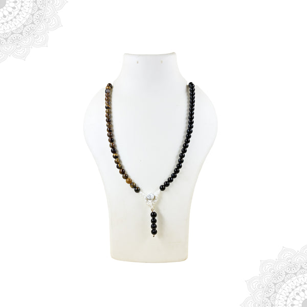 A multi-gemstone mala necklace featuring a split design of Tiger's Eye and shiny Black Tourmaline beads with a white Howlite guru bead, shown on a white mannequin.