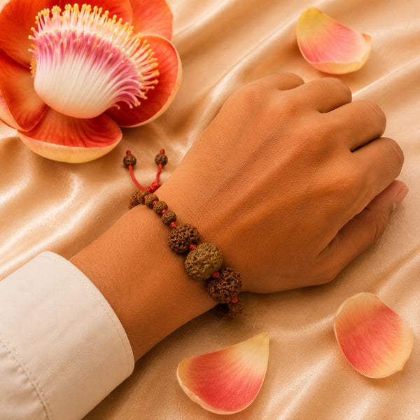 A person wearing the powerful 7, 8, and 5 Mukhi Rudraksha combination bracelet on a red adjustable cord.