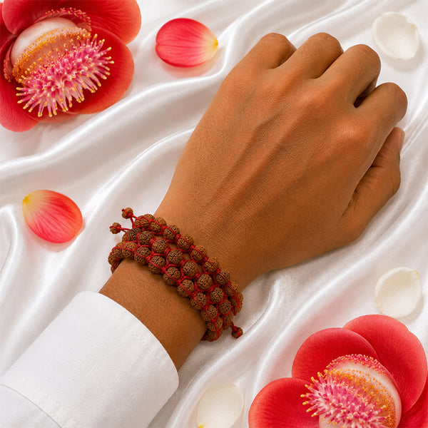 A person wearing the handcrafted triple-strand Rudraksha woven bracelet, showcasing its bold and protective design.